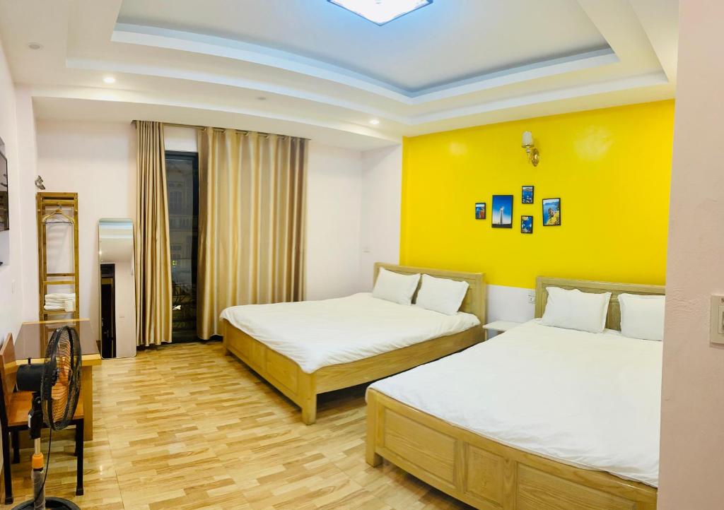 My Dream Hotel في سابا: غرفة بسريرين وجدار اصفر