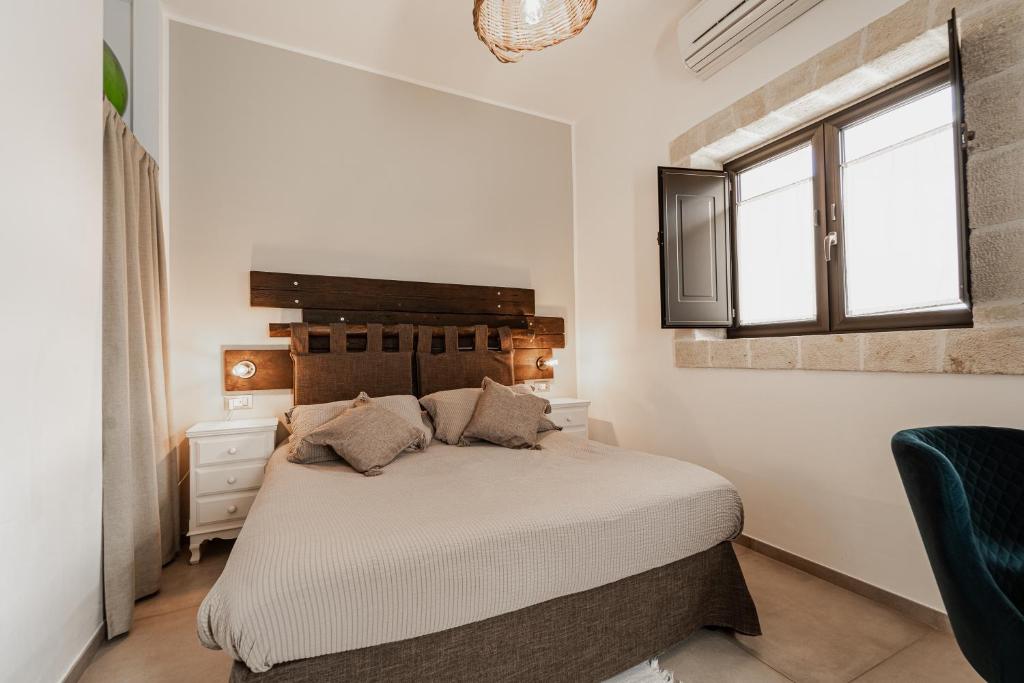 sypialnia z dużym łóżkiem i oknem w obiekcie Oppure - Masseria Moderna w mieście Polignano a Mare