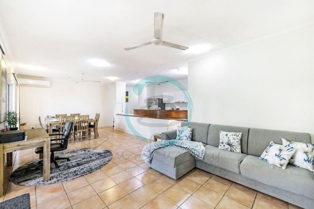 uma sala de estar com um sofá e uma sala de jantar em ZEN FORESHORE Cozy 2-BR, 2-BA Holiday Home + Pool em Nightcliff