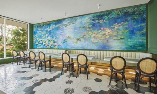 a row of chairs in a room with a large painting at Caesar Park Hotel Kenting in Kenting