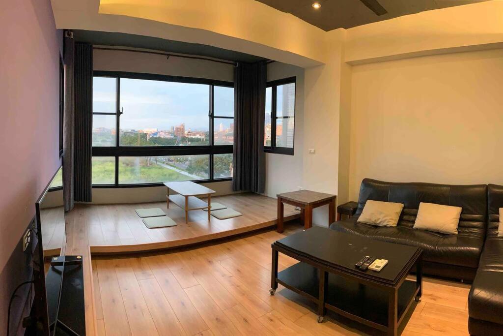 a living room with a couch and a large window at FengJia Pleasure Life 2 in Taichung