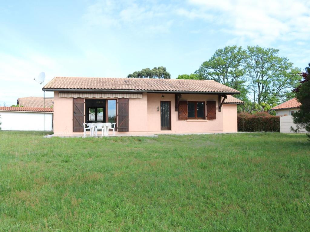 una piccola casa rosa con un prato di Maison Calme avec Jardin, Proche Lac et Centre, Animaux Bienvenus, Ménage Inclus - FR-1-319-408 a Sanguinet