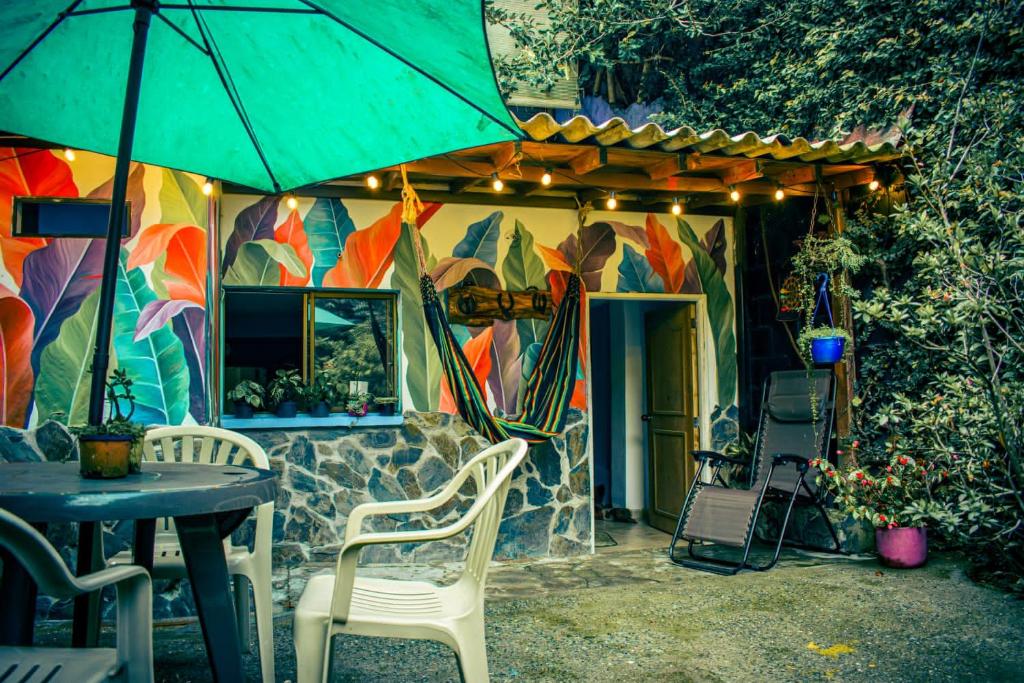 patio con tavolo, sedie e ombrellone di Acogedor apartaestudio ad Armenia
