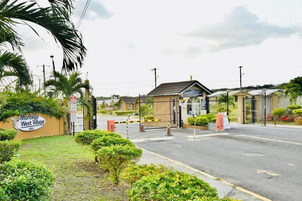 an empty street in a small town with houses at The Rest Stop-B- 15 min from Airport/24hrs Security in Montego Bay