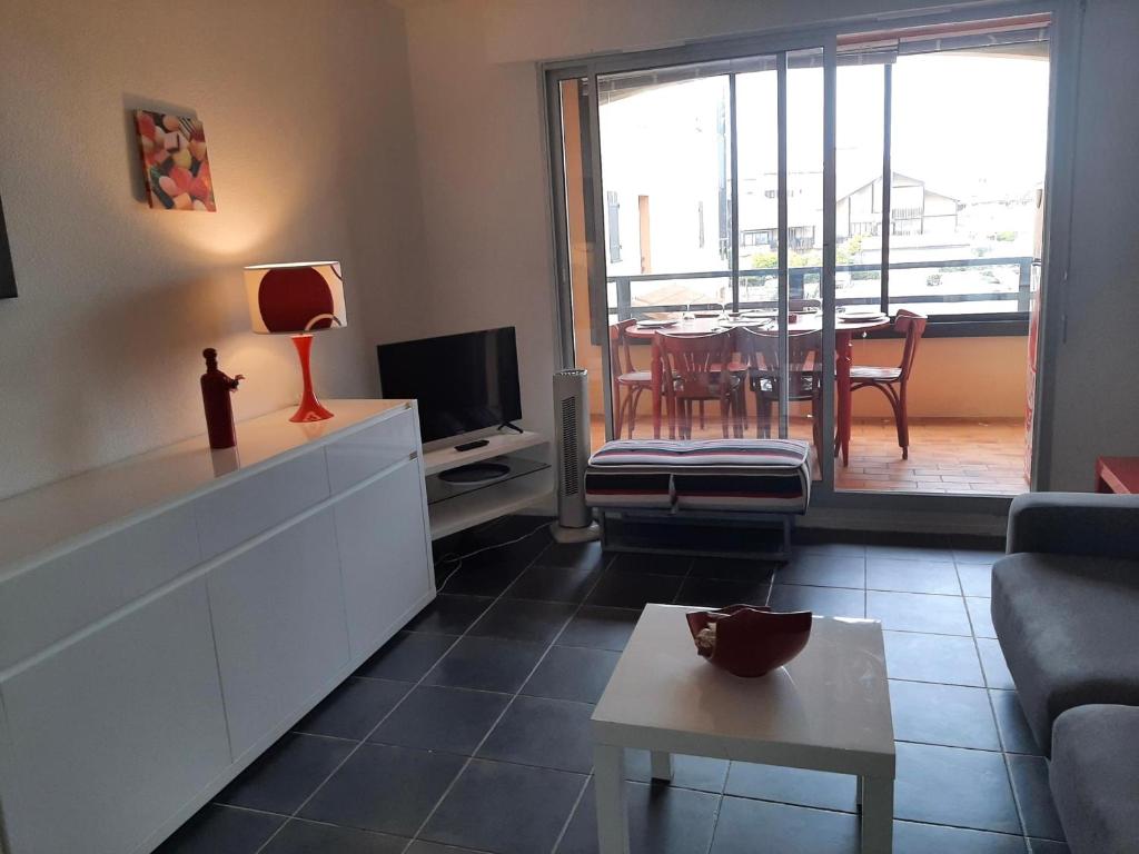 un salon avec un canapé et une télévision dans l'établissement Appartement 4 couchages à Capbreton avec piscine, tennis et plage à pied - FR-1-239-867, à Capbreton