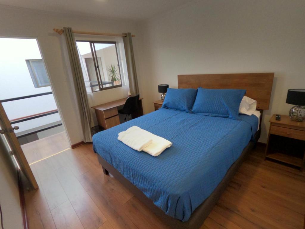 a bedroom with a bed with blue sheets and blue pillows at Hostal La Ruca in Antofagasta
