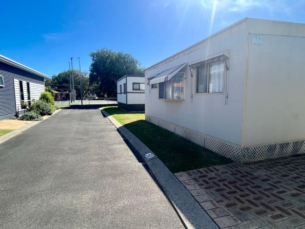 a white building on the side of a street at Family Getaway Cabin 50 in Broadwater