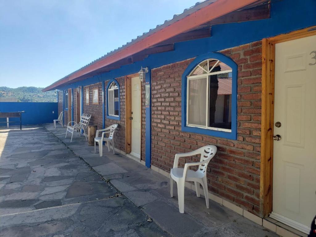 une rangée de chaises assises sur le côté du bâtiment dans l'établissement Sierra Hotel, à Areponapuchi