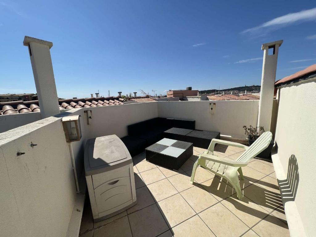 d'un balcon avec une cuisinière et des chaises sur le toit. dans l'établissement Studio Mezzanine avec Piscine, Clim, Parking et Lave-linge - Proche Plage - FR-1-702-50, au Cap d'Agde