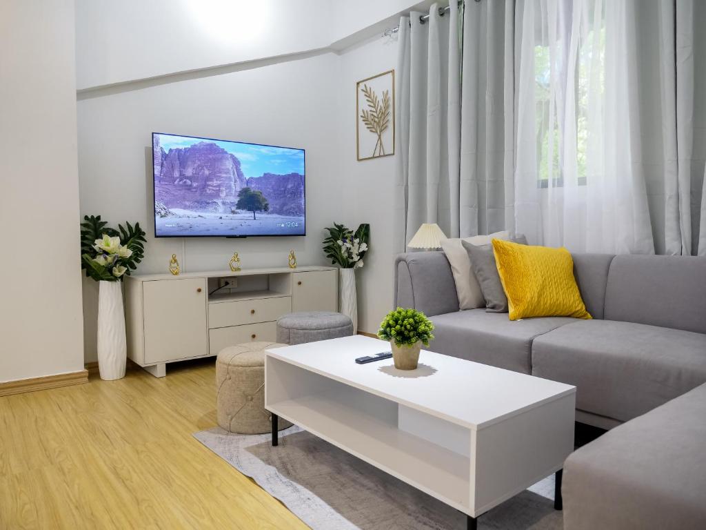 ボラカイにあるFully Furnished 2BR Newly Renovated Apartment by the White Beach - 1min walk from door stepのソファとテレビのあるリビングルーム