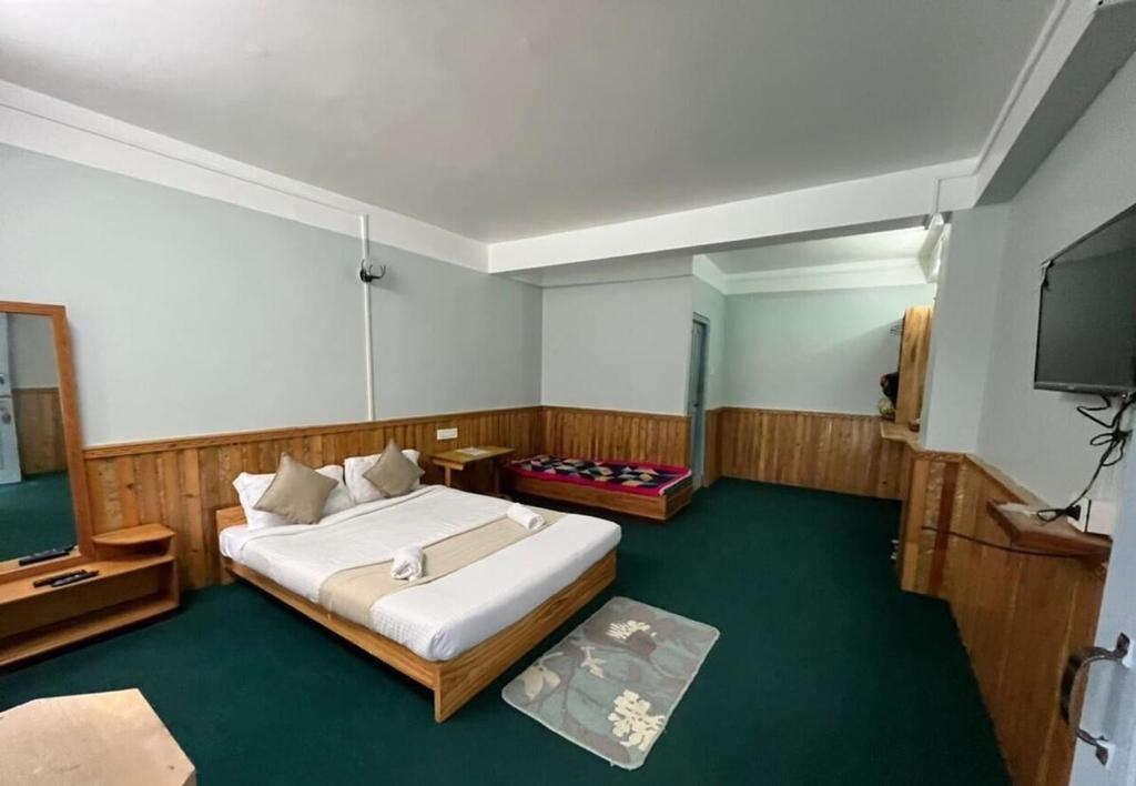 a bedroom with a bed and a flat screen tv at Mount Khang Hotel in Lachen