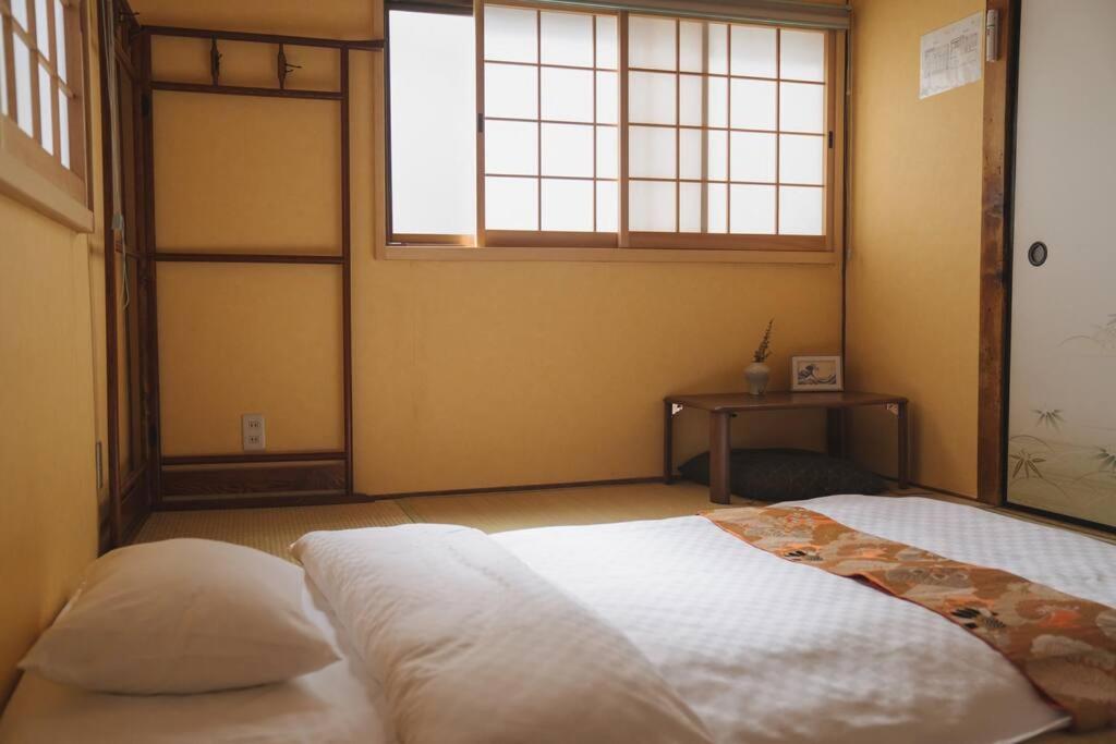 a bedroom with a large bed with a window at Kokoro no sato・Hitomi in Kyoto