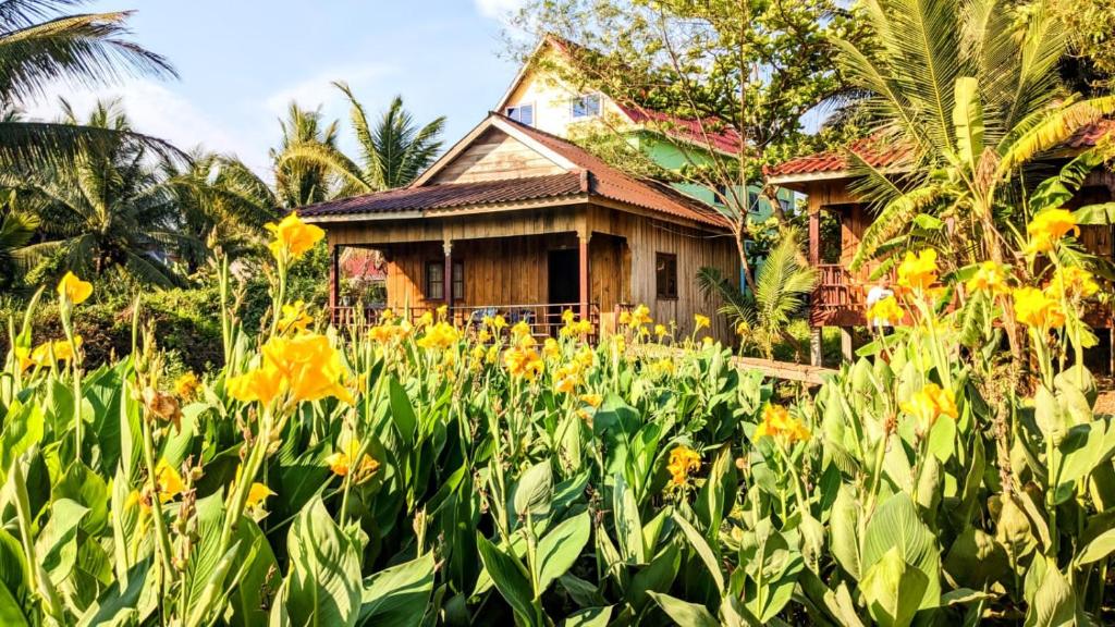 a house in the middle of a field of yellow flowers at Sok Mean Bungalows in Koh Rong Sanloem