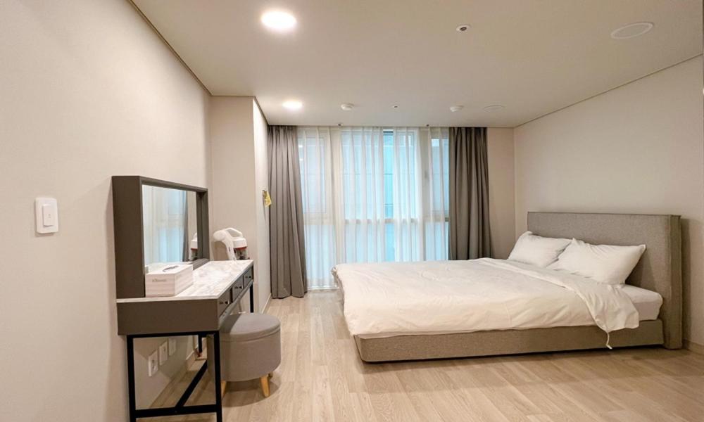 - une chambre avec un lit, un lavabo et un miroir dans l'établissement Busan Centurn Victoria hotel, à Busan