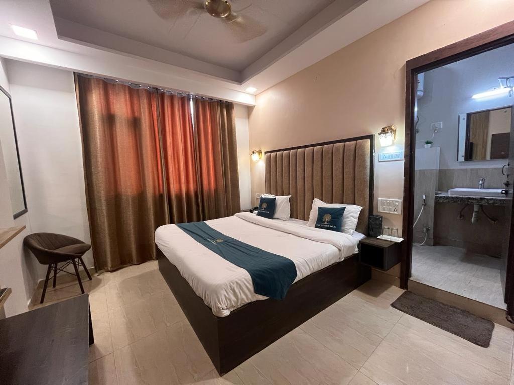 a bedroom with a large bed and a bathroom at The Divine Oak in Katra