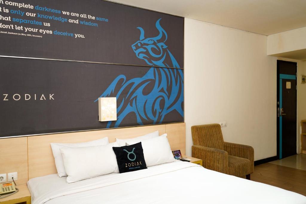 a bedroom with a bed with a sign on the wall at Zodiak Paskal by KAGUM Hotels in Bandung