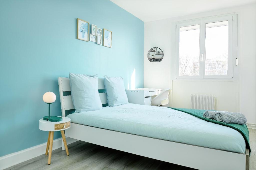 una camera blu con un letto e una finestra di Appartement Prestige - Amiens ad Amiens