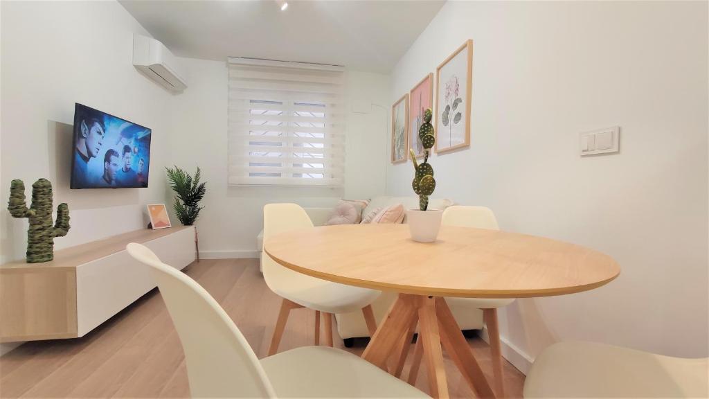 a dining room with a wooden table and white chairs at Apartamento Elena - coqueto, tranquilo y céntrico in Murcia