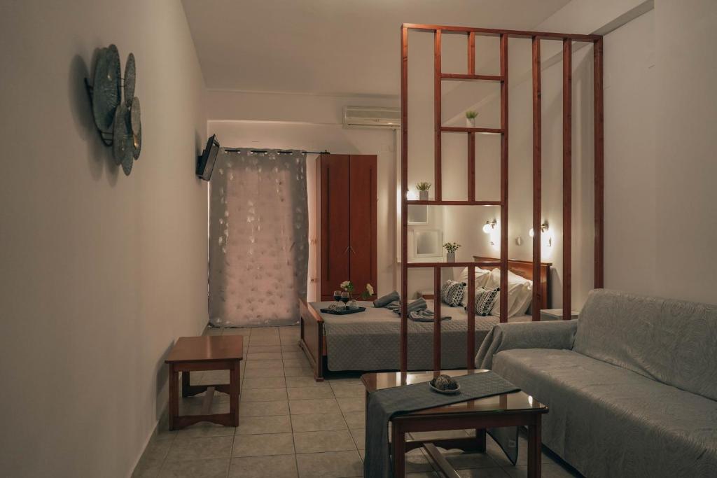 ein Wohnzimmer mit einem Sofa und einem Bett in der Unterkunft DANDOLOS STUDIOS in Parga