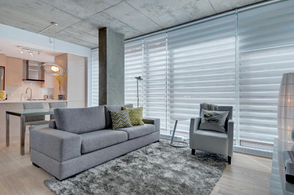 a living room with a couch and a chair at Les Immeubles Charlevoix - Le 760306 in Quebec City