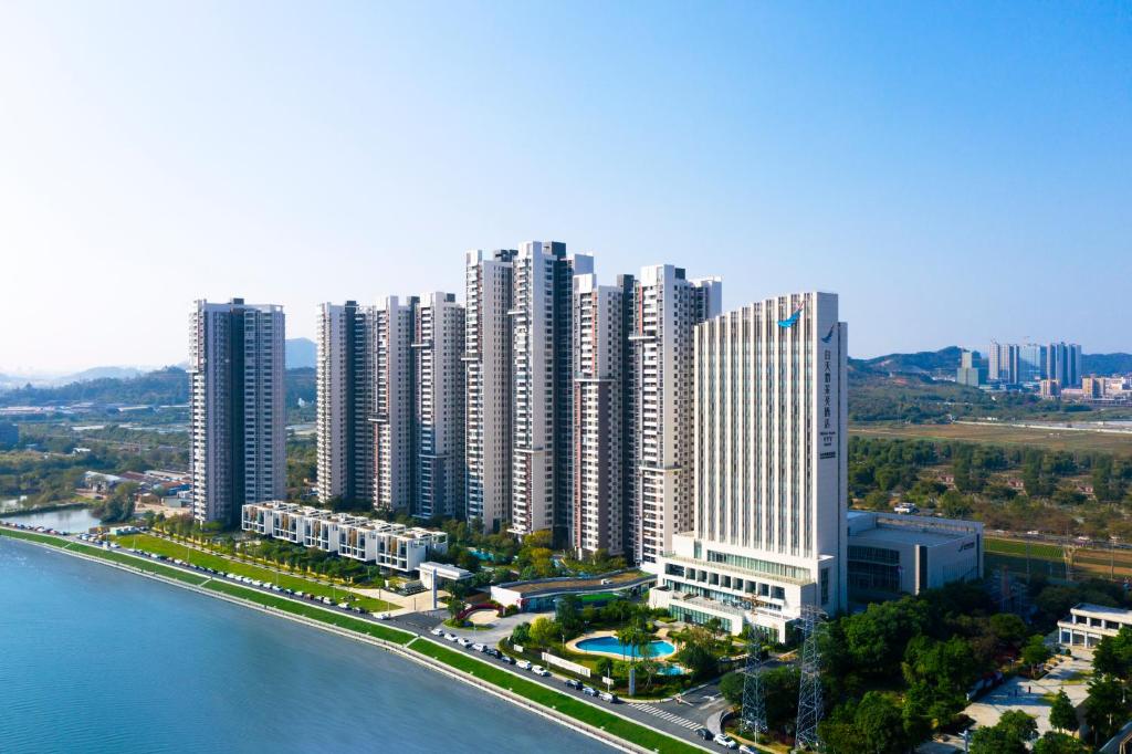 duże miasto z wysokimi budynkami obok wody w obiekcie White Swan VYV Hotel, Foshan w mieście Foshan