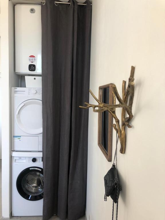 a black curtain in a room with a washing machine at Belle vue sur mer, très près du port de Sanary in Sanary-sur-Mer