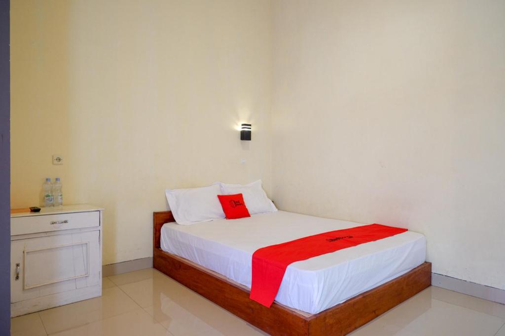 Un dormitorio con una cama con una manta roja. en RedDoorz near Candi Cetho Karanganyar en Karanganyar