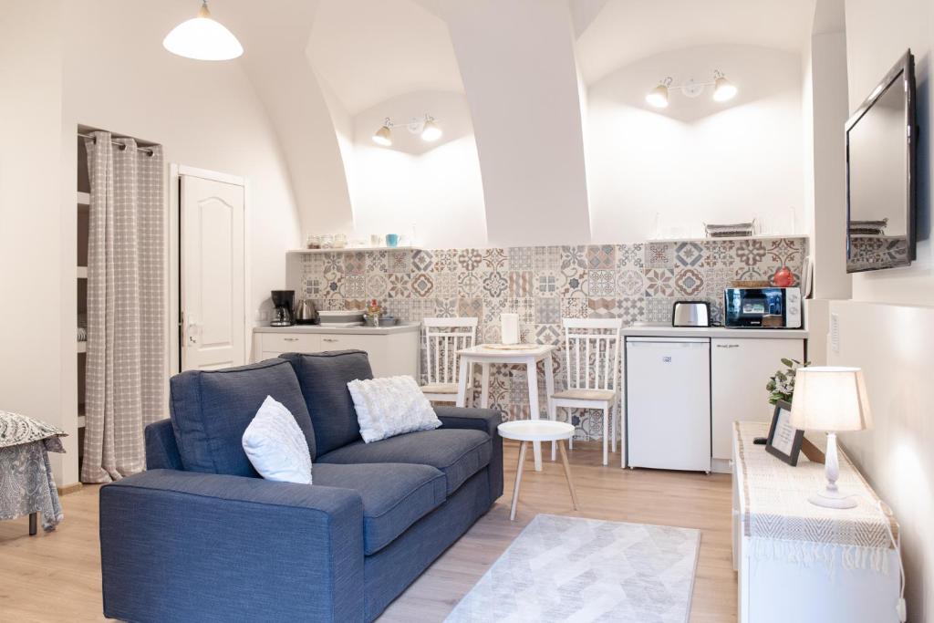 a living room with a blue couch and a kitchen at Center feelings studio by Alandala in Cluj-Napoca