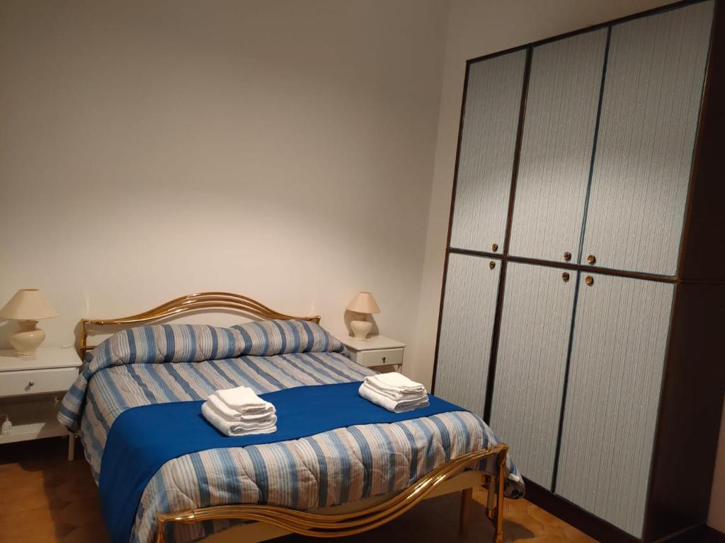 - une chambre avec un lit doté de draps bleus et une armoire dans l'établissement Sa Stiddiosa Guesthouse, à Gadoni