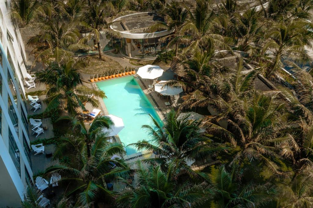 an aerial view of a resort pool with palm trees at Sala Tuy Hoa Beach Hotel in Tuy Hoa