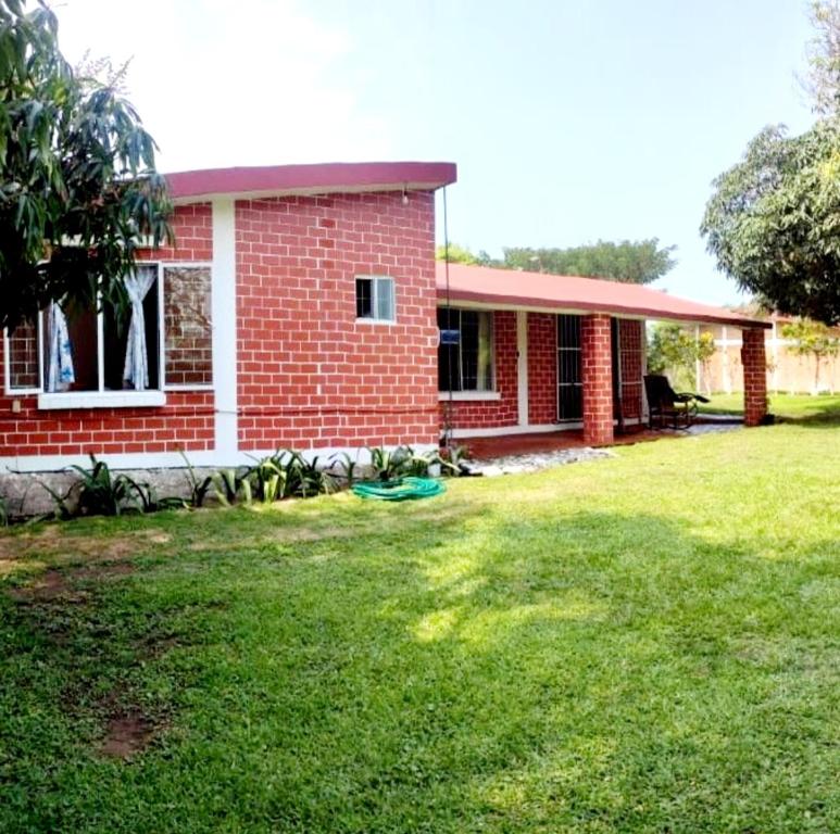 una casa de ladrillo rojo con un patio delante en Casa para vacacionar en la playa, en Casitas