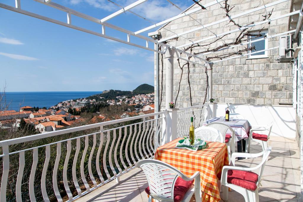 balcón con mesa, sillas y vistas al océano en Apartment Angelina, en Dubrovnik