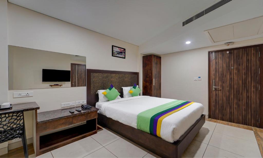 a bedroom with a bed and a desk and a television at Treebo Trend Vetri Supreme Residency in Chennai