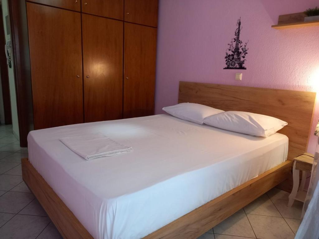 łóżko z białą pościelą i poduszkami w pokoju w obiekcie Dimos w Salonikach