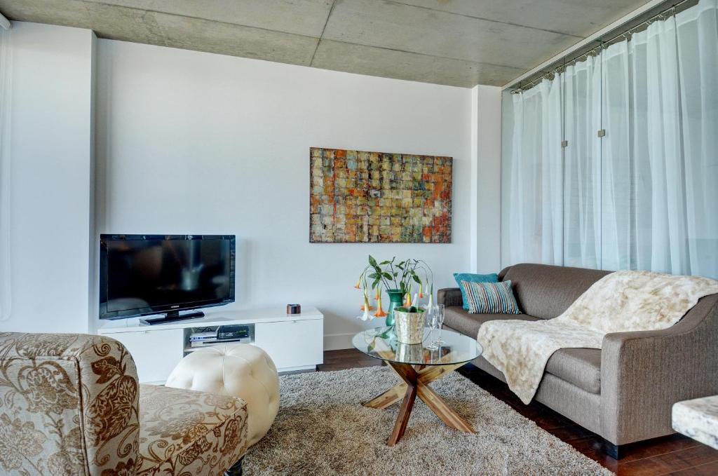 sala de estar con sofá y TV en Les Immeubles Charlevoix - Le 760314, en Quebec