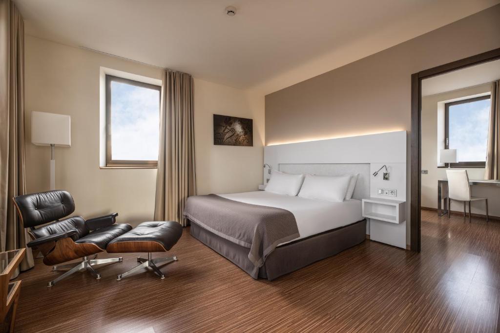 a hotel room with a bed and a chair at Eurostars Vía de la Plata in Astorga