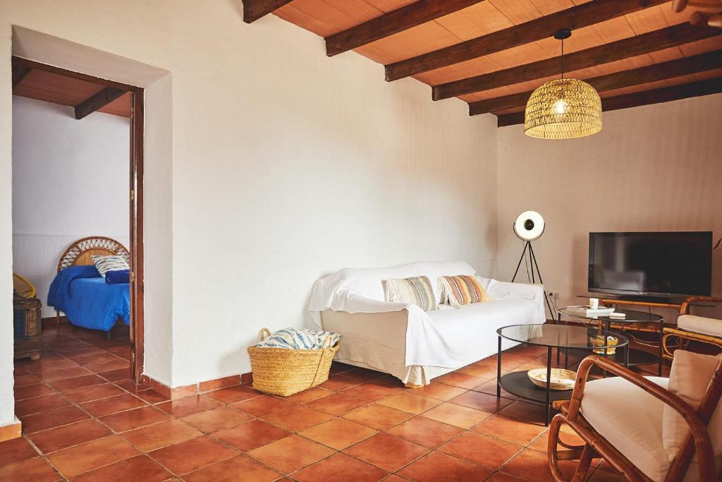 Un dormitorio con una cama, una mesa y un televisor. en Cortijo El Guarda, en Almería
