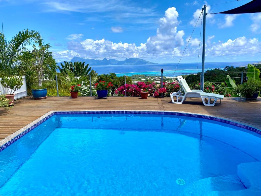 a swimming pool with a chair and a swing at Villa Green in Punaauia