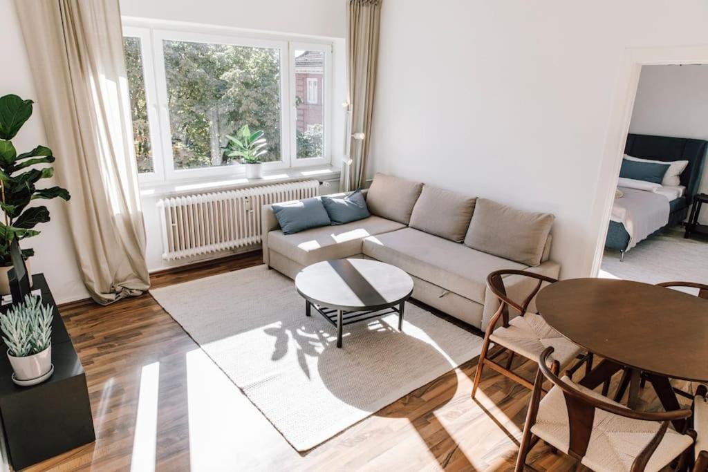 een woonkamer met een bank en een tafel bij Komplett neu: 2-Zi zentral im Altbau. 24h-Checkin in Kiel