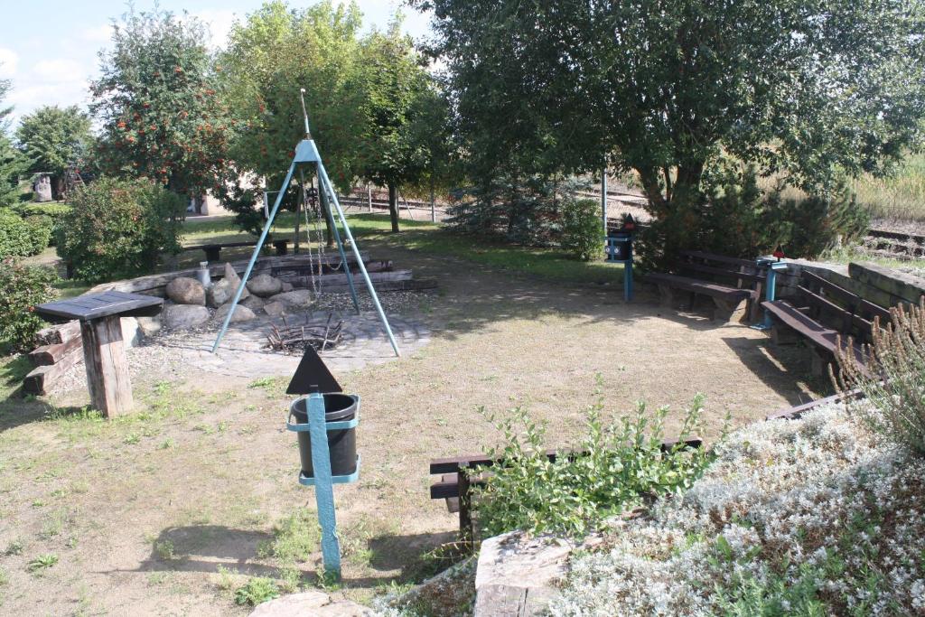 einen Park mit Bänken und Vogelfutter und einer Stange in der Unterkunft Lokschuppen Pasewalk- Gästehaus Lokschuppen in Pasewalk