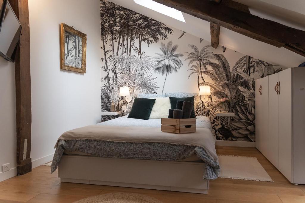 a bedroom with a bed with a tropical wallpaper at Maison dans le centre historique pour 6 personnes avec terrasse et parking in Pau