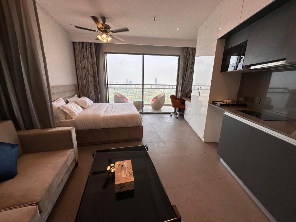 uma sala de estar com uma cama, um sofá e uma mesa em 21st Floor SkyStudio Suite with Balcony em Nova Deli