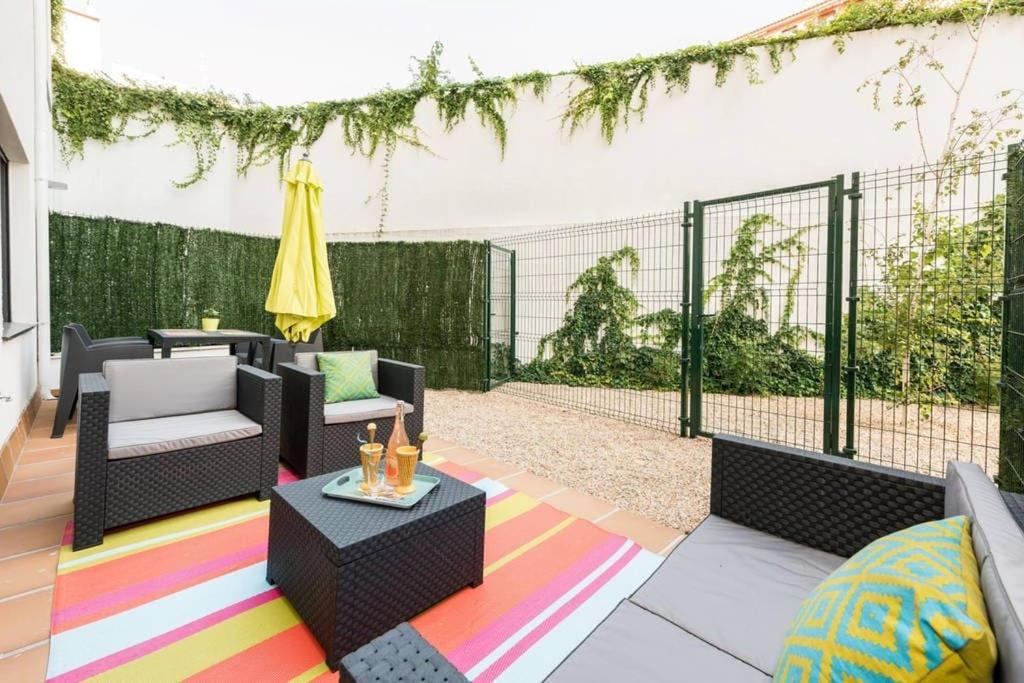 um pátio com cadeiras e uma mesa sobre um tapete colorido em Apartamento con jardin privado y portero (B) em Madri