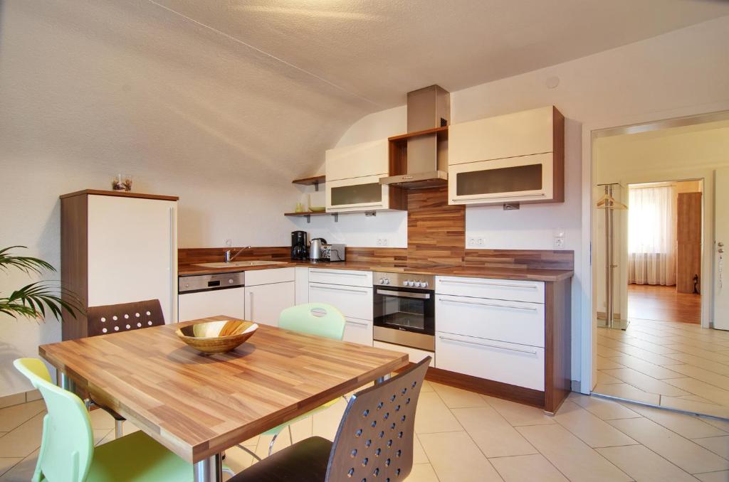 a kitchen with a wooden table and a dining room at Ferienwohnung Hornisgrindeblick in Obersasbach