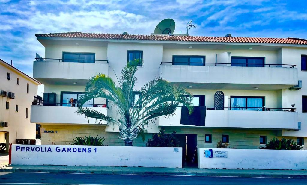 un edificio con una palmera delante de él en Stunning 1-Bed Apartment in Larnaca near the sea, en Perivolia