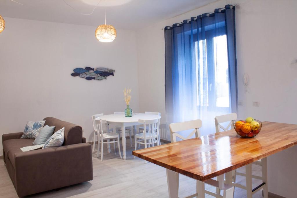 een woonkamer met een tafel en een bank en een eetkamer bij Blu Mare Apartment in Alghero