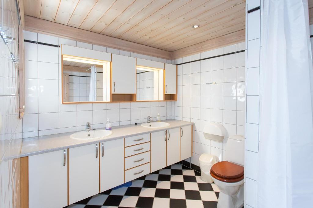 a bathroom with two sinks and a checkered floor at Topcamp Bie - Grimstad in Grimstad