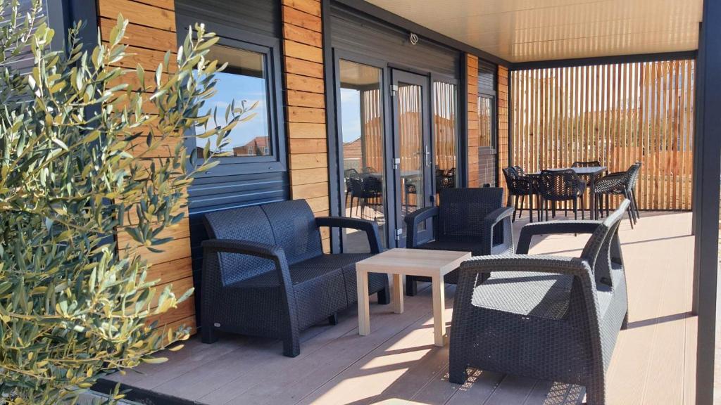 a patio with chairs and tables on a building at Mobile homes Tina Pakoštane in Pakoštane