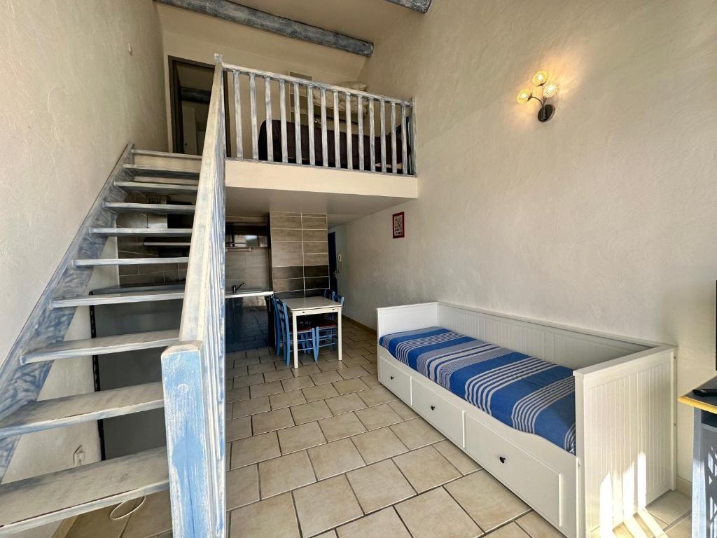 a bedroom with a bunk bed and a staircase at Résidence La Palma in Saintes-Maries-de-la-Mer