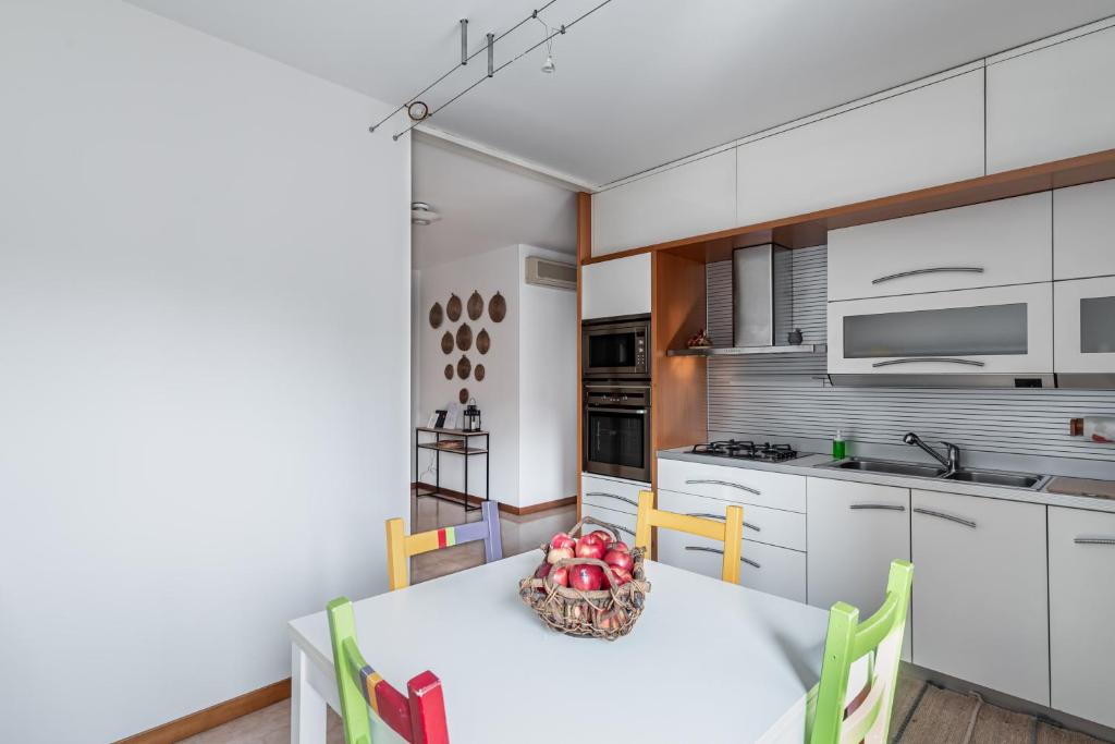 een keuken met een tafel en een fruitschaal bij Padova Palestro Pastel Apartment in Padua